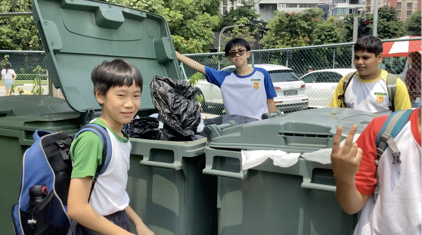 Students assisting in emptying the trash
